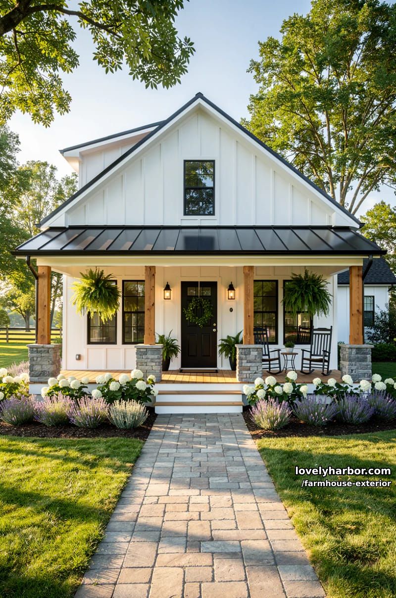 white farmhouse with black windows, gabled roof, and welcoming porch with greenery. 1