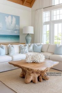 airy coastal living room with cream sectional, tree root coffee table, and seascape art. 21