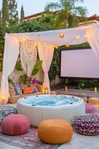 outdoor home theater with hot tub, floor cushions, canopy, and boho decor. 7