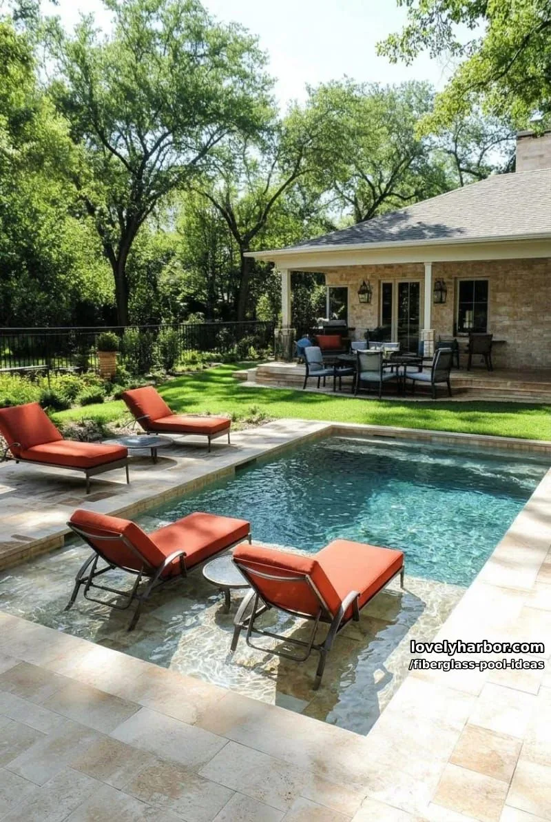 20 Fiberglass Pool Ideas for a Cozy Outdoor Retreat 9 rectangular pool with tan brick patio, red submerged loungers, and multiple seating areas. 1