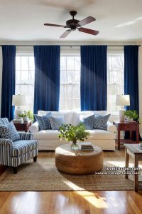 20 Coastal Cottage Living Room Designs for a Fresh Look 1 white sofa, blue patterned pillows, blue curtains, and rattan coffee table. 18