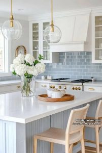 modern kitchen with white cabinetry, brass accents, and blue tile backsplash. 2