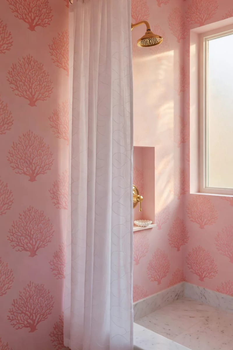 20 Pink Coastal Bathroom Ideas With a Breezy Finish 17 close-up of pink coral-patterned wall and semi-sheer shower curtain. 1