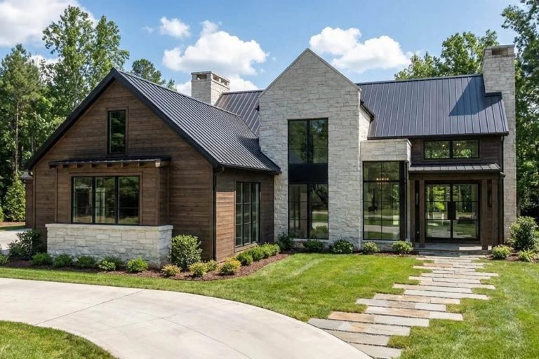 Modern home exterior with wood, stone, metal roof, and large black-framed windows.