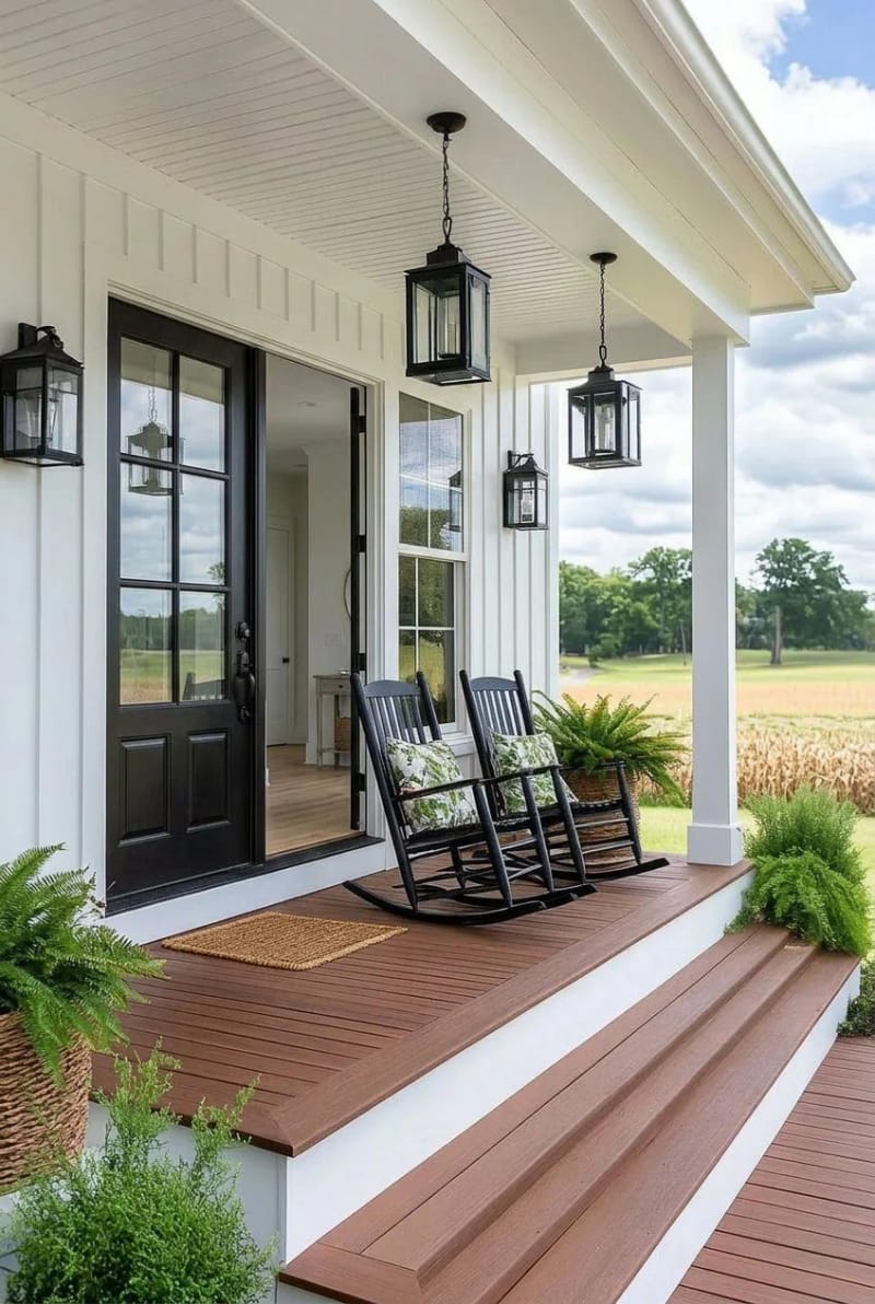 farmhouse porch with beadboard ceiling, double doors, rocking chairs, and ferns. 1