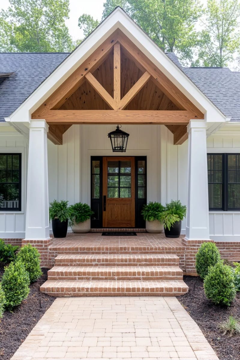 farmhouse porch with gable roof, brick steps, wood door, and lantern light. 1