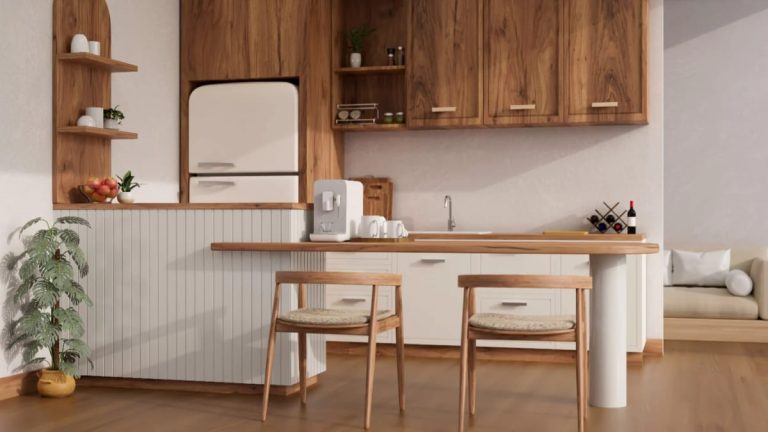 Japandi Kitchen Ideas: 10 Design Decisions That Keep It Warm, Not Clinical 1 A Japandi style kitchen with natural wood cabinets, minimalist white appliances, a wooden breakfast bar with two chairs, open shelving with simple decor, and a potted plant, illustrating a warm and inviting kitchen design.