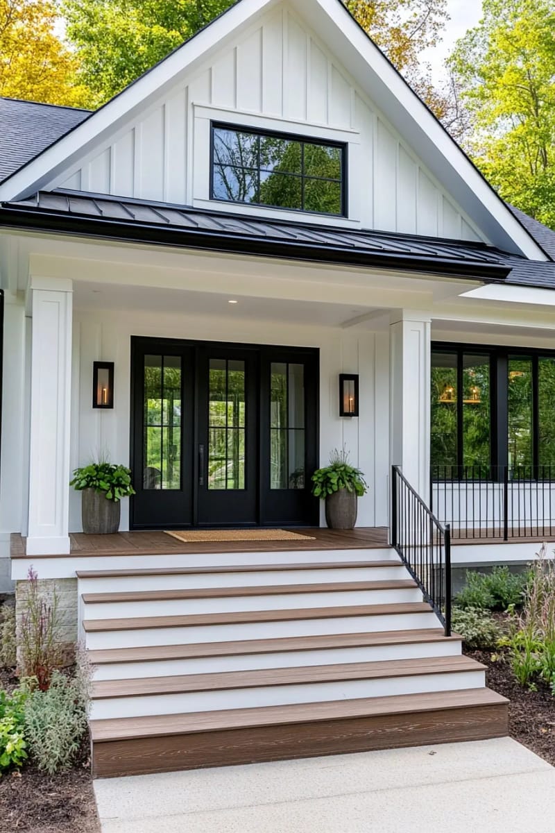 modern farmhouse with board and batten siding, metal roof, and black railings. 1