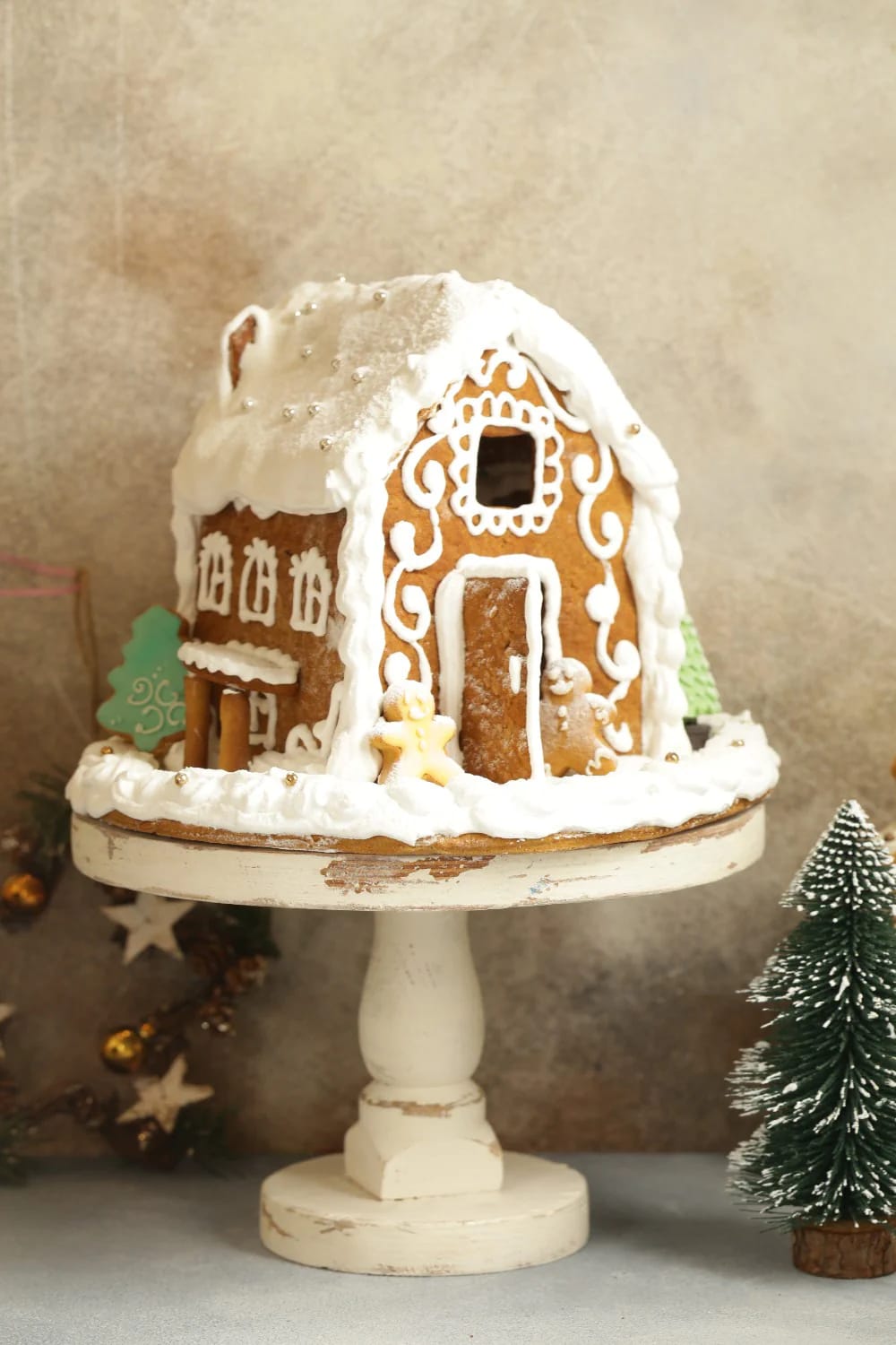 one gingerbread house, on a cake stand, under a cloche 1