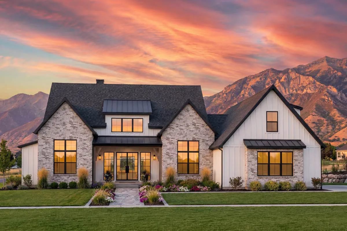 Modern farmhouse exterior with gabled roof, brick and board-and-batten siding, and large black-framed windows