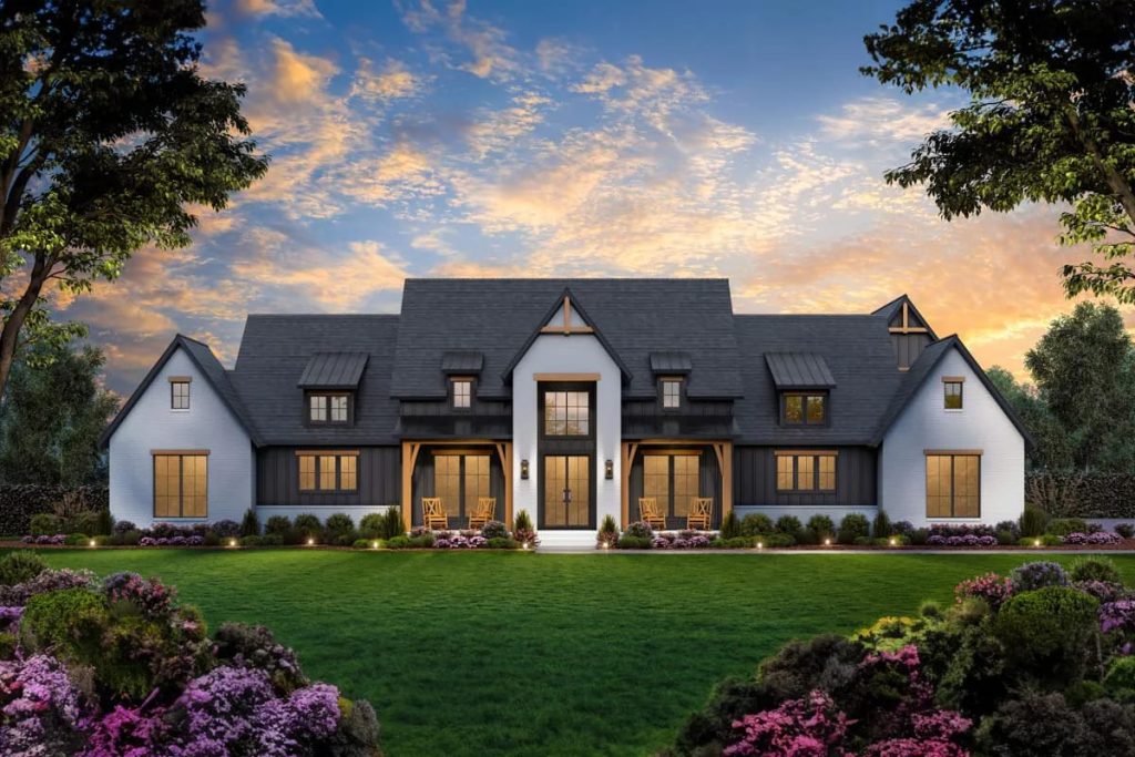 Modern farmhouse exterior with white brick, dark siding, and steep gabled roof at sunset.
