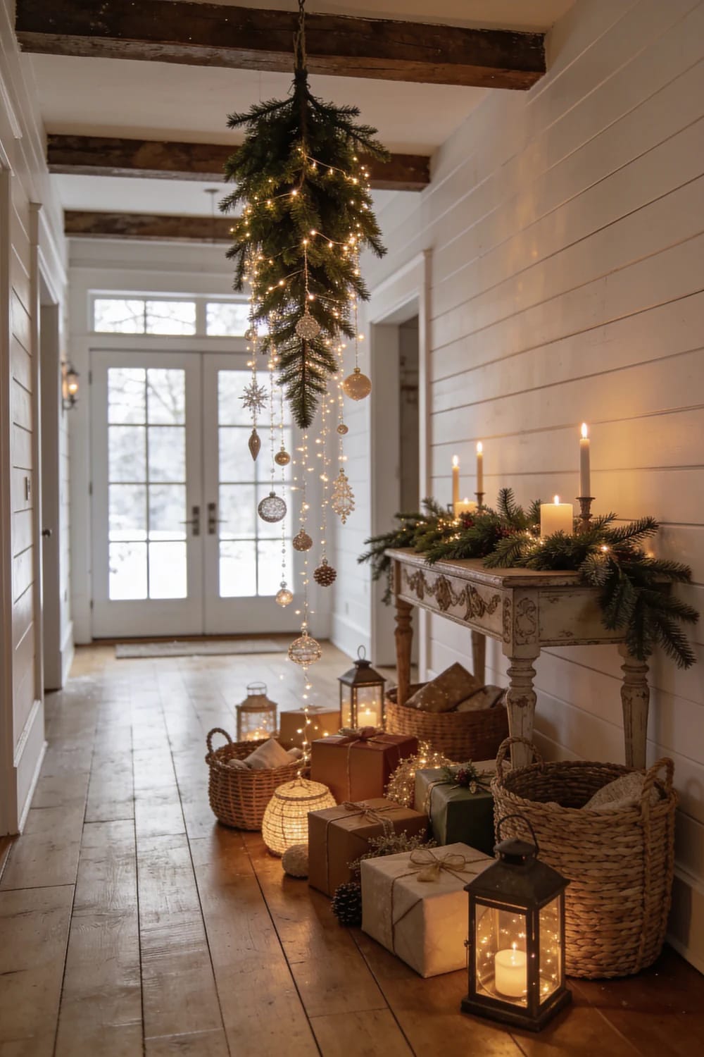 Christmas Hallway Ceiling Decor Ideas for Narrow Halls and Low Ceilings 7 A narrow hallway decorated for Christmas with an upside-down evergreen branch hanging from the ceiling, adorned with string lights and ornaments, above a rustic console table with candles and greenery, and wrapped gifts and lanterns on the wooden floor, illustrating Christmas hallway ceiling decor ideas for low ceilings.