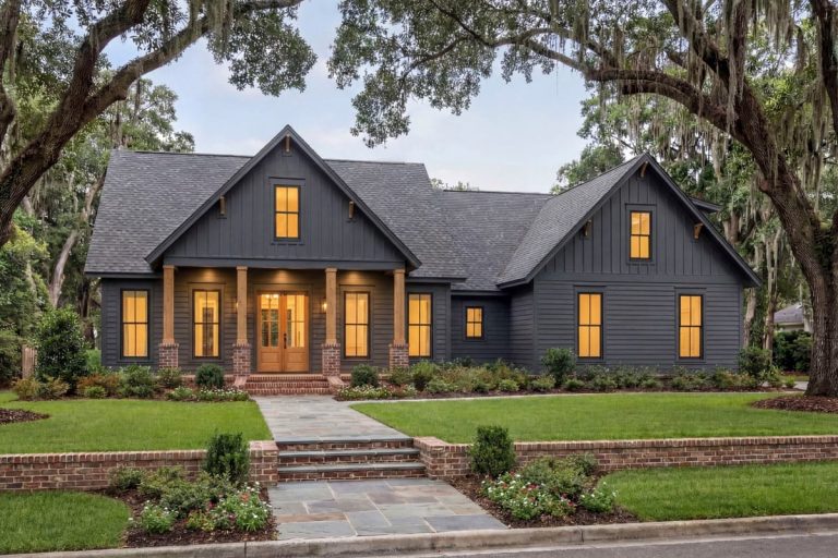 Modern farmhouse with dark siding, wood columns, brick accents, and a welcoming front porch