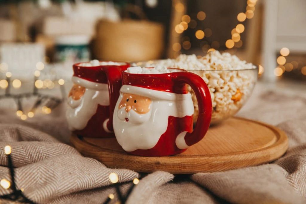 Lovely Harbor 43 Two Santa-shaped mugs filled with marshmallows on a wooden tray next to a bowl of popcorn, illustrating a festive way to display a Santa mug collection.