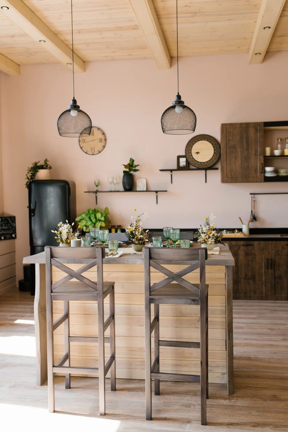 Kitchen Island With Dining Table: 11 Combinations That Actually Get Used 5 Modern kitchen featuring a kitchen island with a 36-inch dining table surface, set with place settings and floral arrangements, accompanied by high wooden chairs with backs, illustrating a usable kitchen island with dining table combination.
