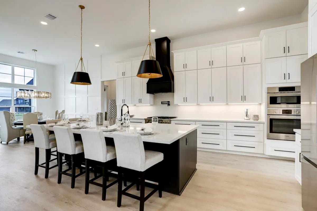 4-Bedroom Modern Farmhouse House Plan with a Vaulted Great Room and Bonus Room (2,877 Sq. Ft. Floor Plan) 8 kitchen cabinets stacked to a 12-foot ceiling, and a black hood in the middle of them 1