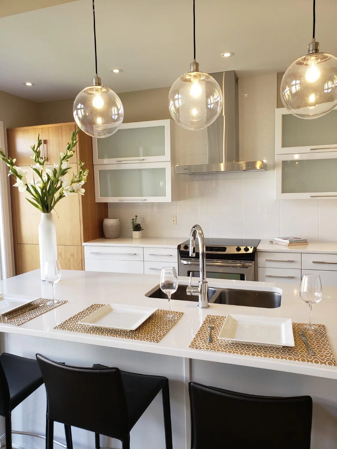 Kitchen Island With Dining Table: 11 Combinations That Actually Get Used 21 Modern kitchen island with dining table setup, featuring three pendant lights above the island and recessed ceiling lights above the cooking area, illustrating separate lighting for each half of the space.