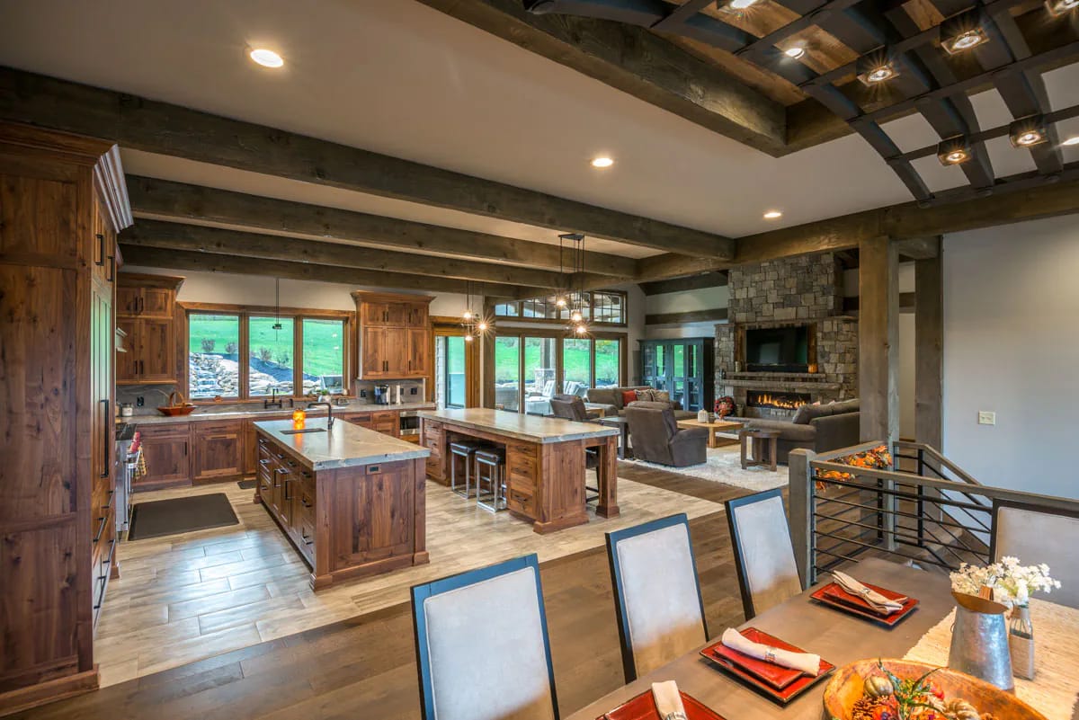 3-Bedroom Mountain Ranch House Plan with an Optional Finished Lower Level (3,623 Sq. Ft. Floor Plan) 7 two islands, walnut-toned cabinetry, and a beam grid over the dining table 1