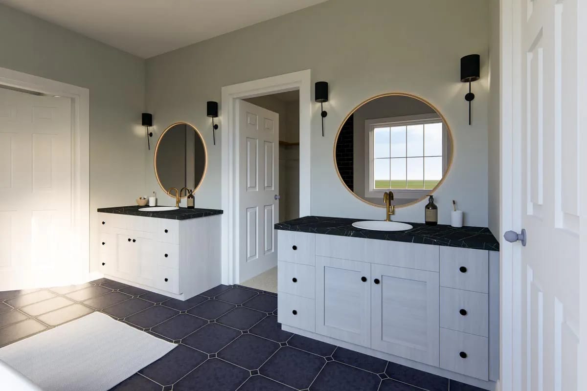 Contemporary bathroom with dual white vanities, dark tile flooring, round mirrors, and brass fixtures