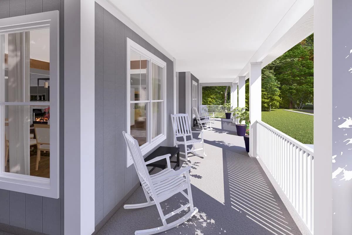 Covered porch with gray siding, white columns, rocking chairs, and wooded lawn beyond