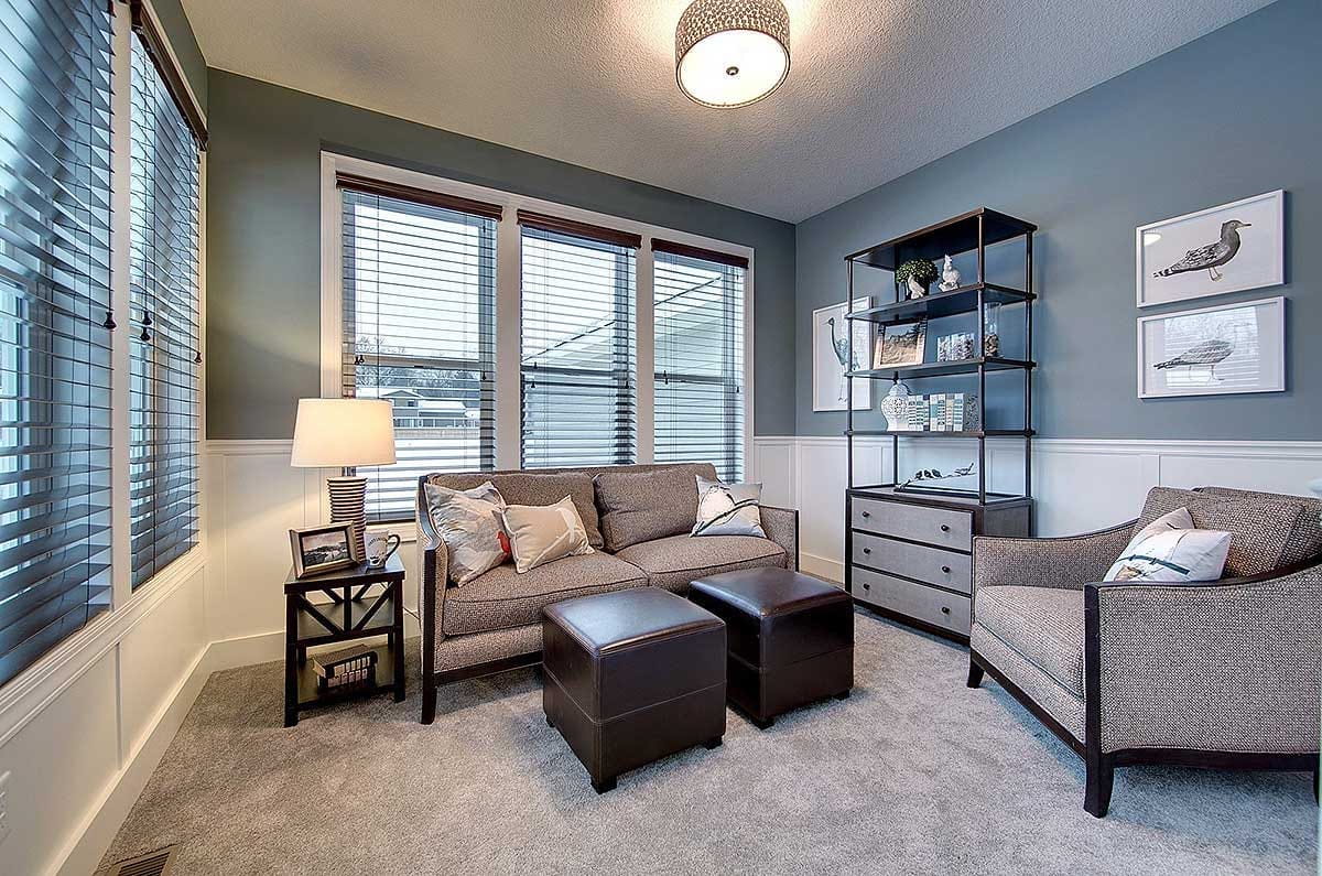 Cozy sitting room with blue-gray walls, white wainscoting, and modern upholstered furnishings