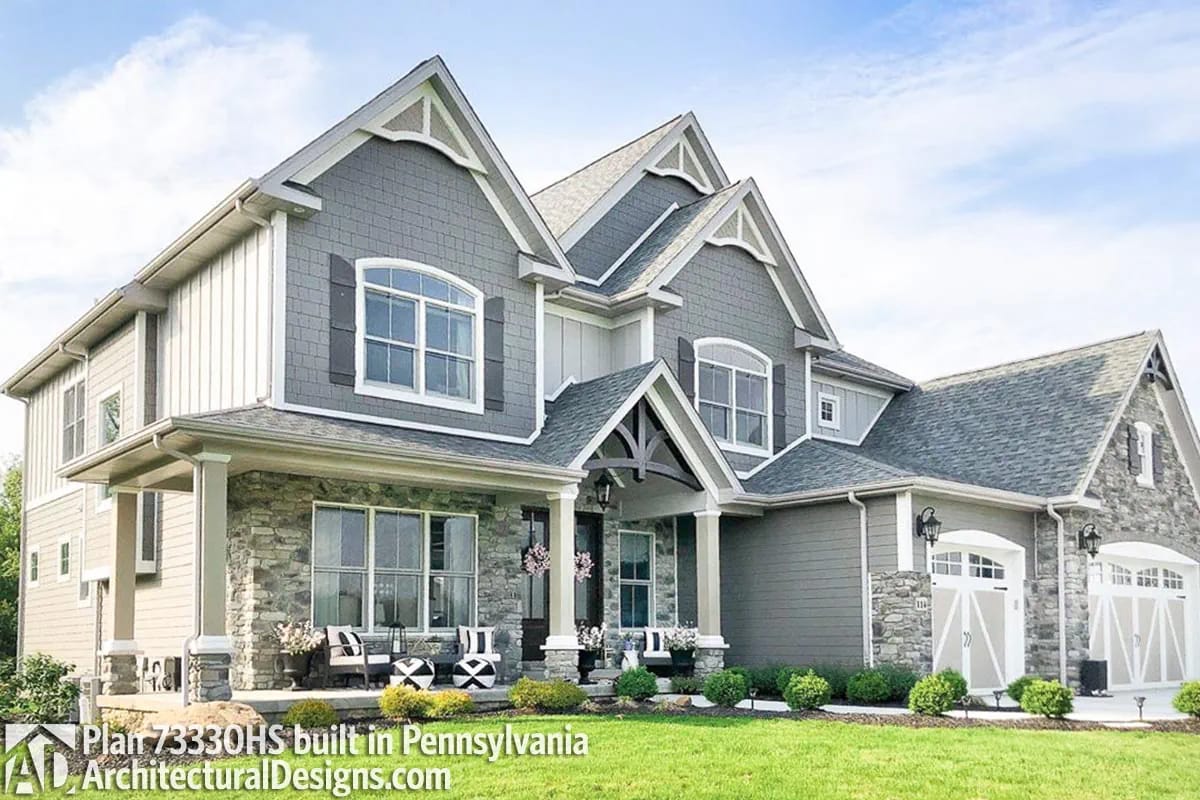 Gray craftsman-style home with stone accents, front porch, and multiple gables