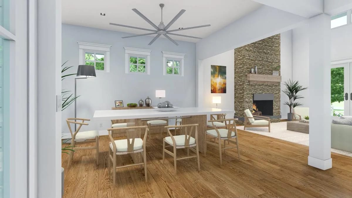 Open dining and living room with stone fireplace, wood floors, light furnishings, and a large modern ceiling fan