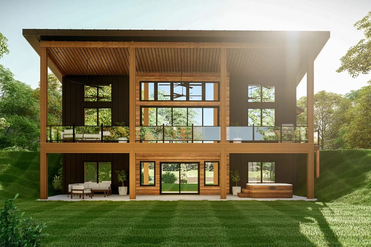 Rear exterior of a contemporary two-story wood-clad home with glass balcony, covered patio, and outdoor spa