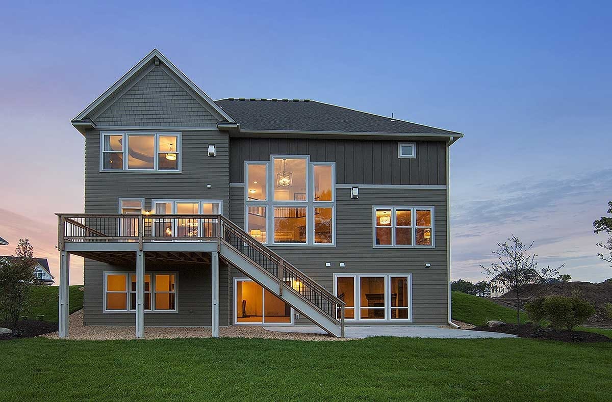 Rear exterior rendering of a modern home with large windows, elevated deck, and walkout basement at dusk.