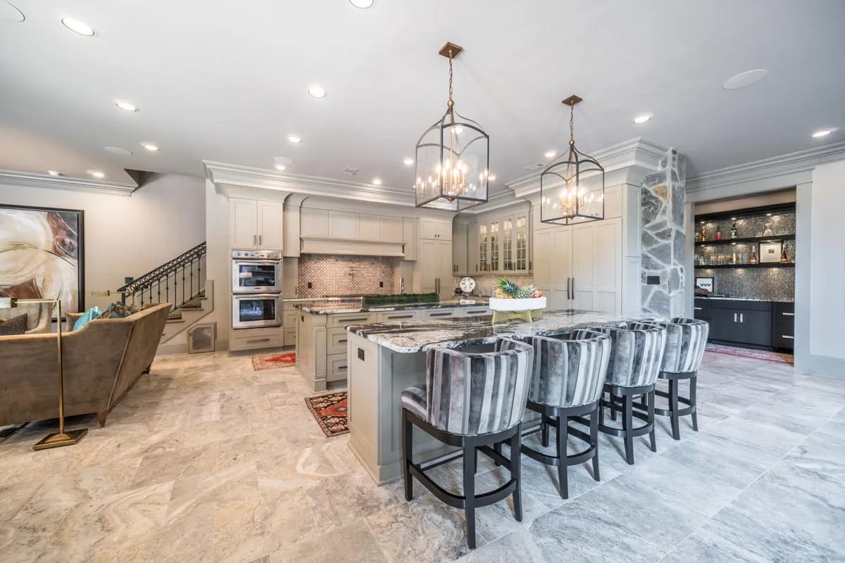 Spacious open kitchen with granite island, gray cabinetry, and adjacent living area