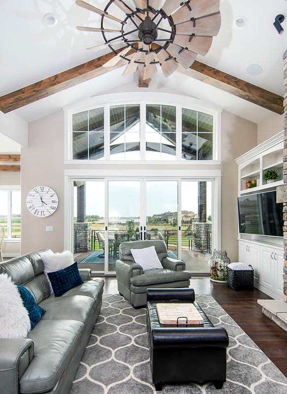 Vaulted living room with exposed beams, large windows, and contemporary furnishings
