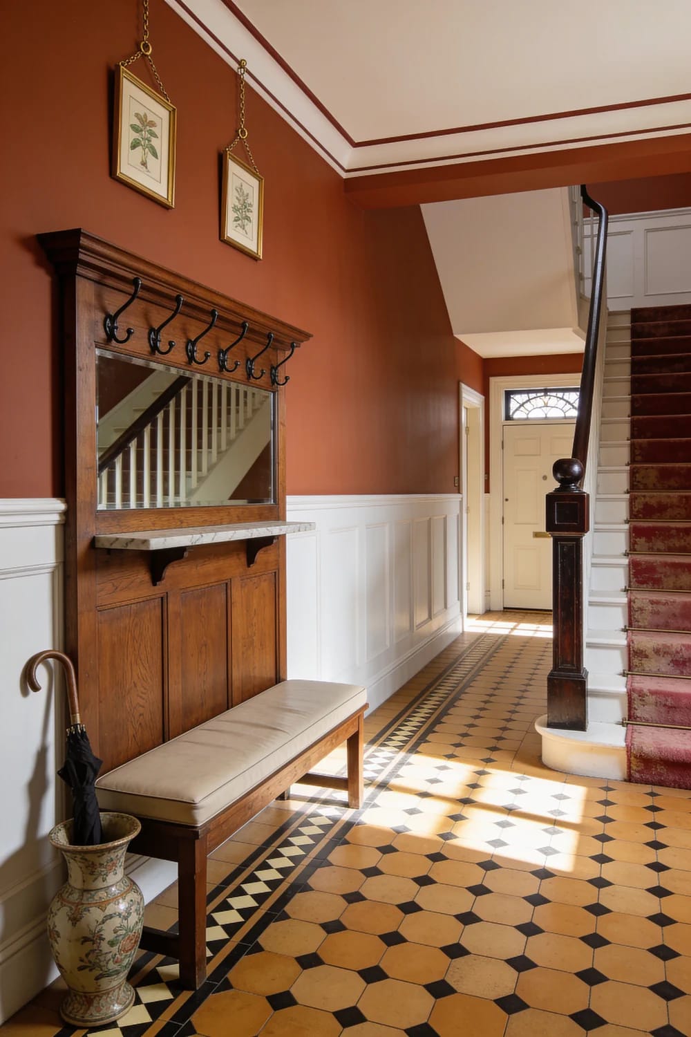 Victorian Homes: What the Good Ones Get Right 3 Victorian entry hall with terracotta walls, white paneling, patterned tile flooring, a wood coat rack and mirror, bench, umbrella stand, front door, and carpeted staircase