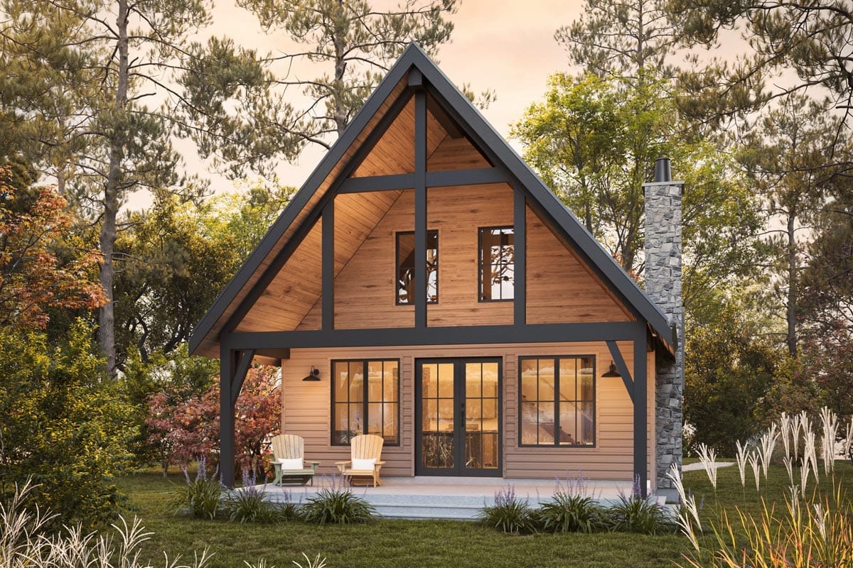A-frame wood home with dark trim, stone chimney, glazed gable, and covered porch in a wooded setting A-frame wood home with dark trim, stone chimney, glazed gable, and covered porch in a wooded setting