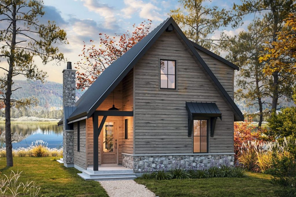 Steep-gabled lakeside cottage with weathered wood siding, stone base, covered entry, and dark metal roof